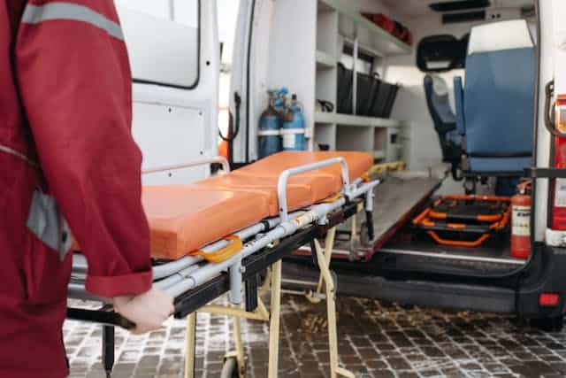 Paramedic holding an ambulance bed after a lyft or uber accident.