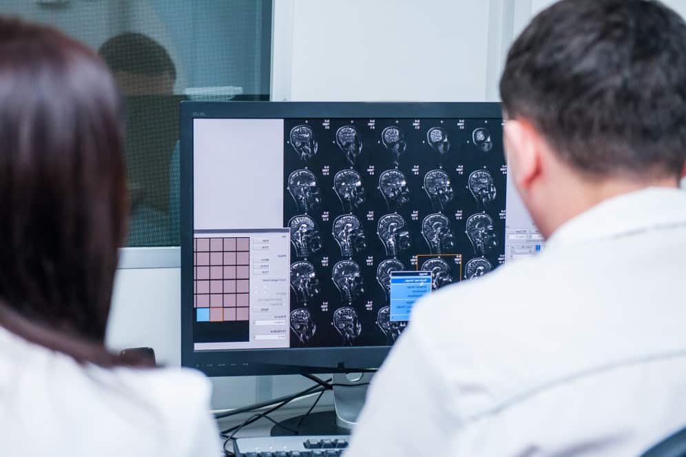 Two doctors examine an x-ray of a patient with a brain injury.