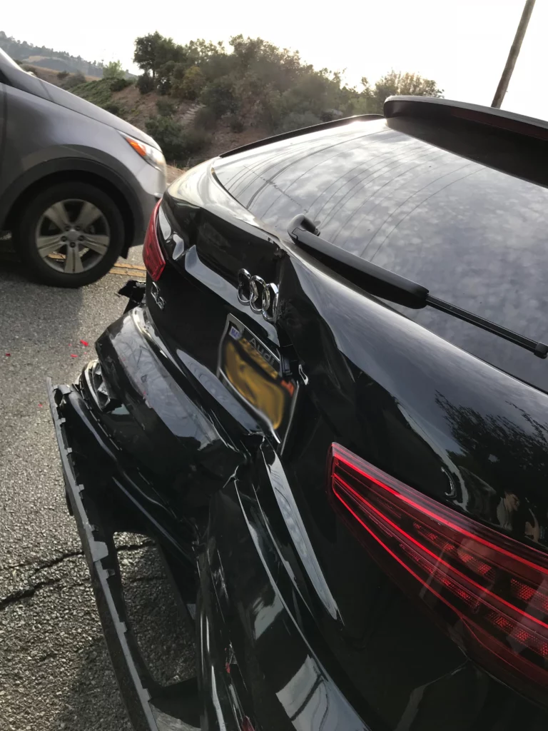 The rear of the victim's car, damaged after the collision.