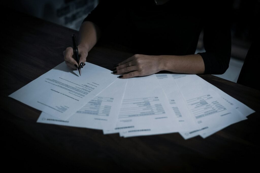 Mujer firmando papeles de caso de lesiones por resbalón y caída