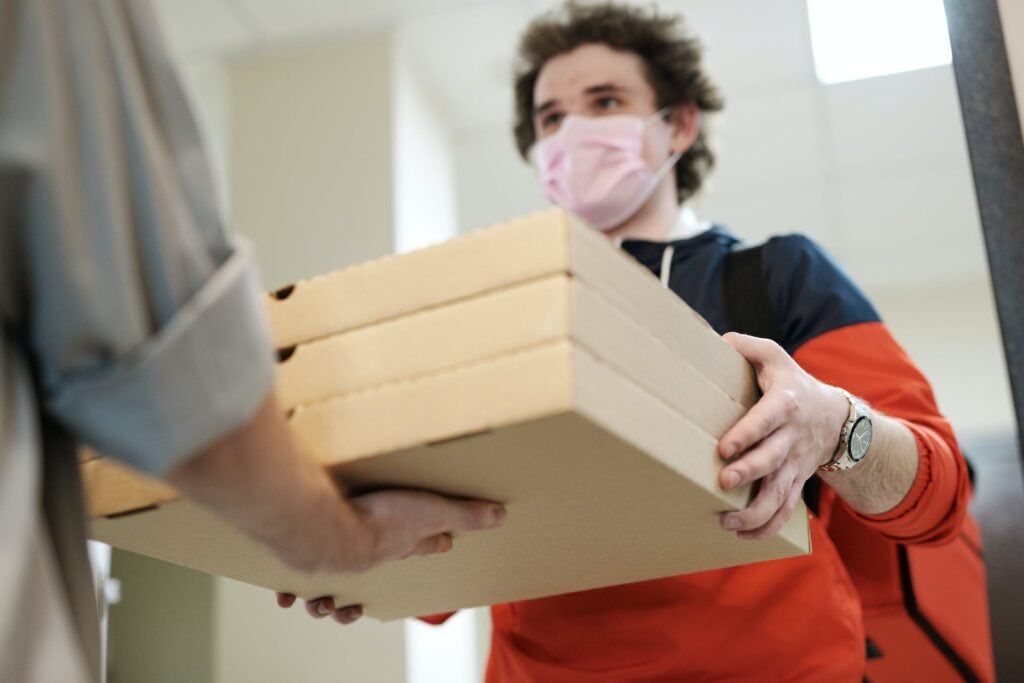 Man holding three pizza boxes