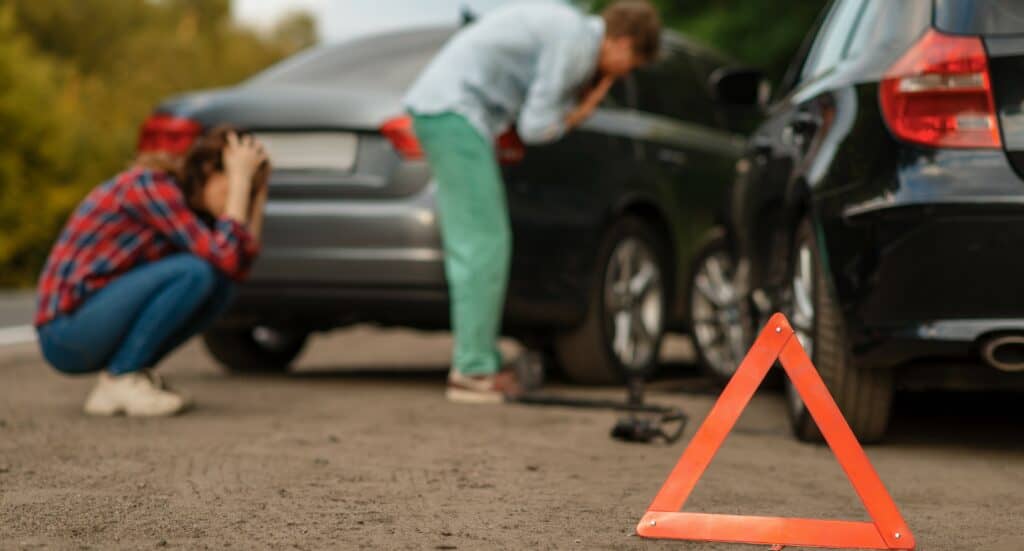 Dos personas lamentándose tras un accidente de tránsito.