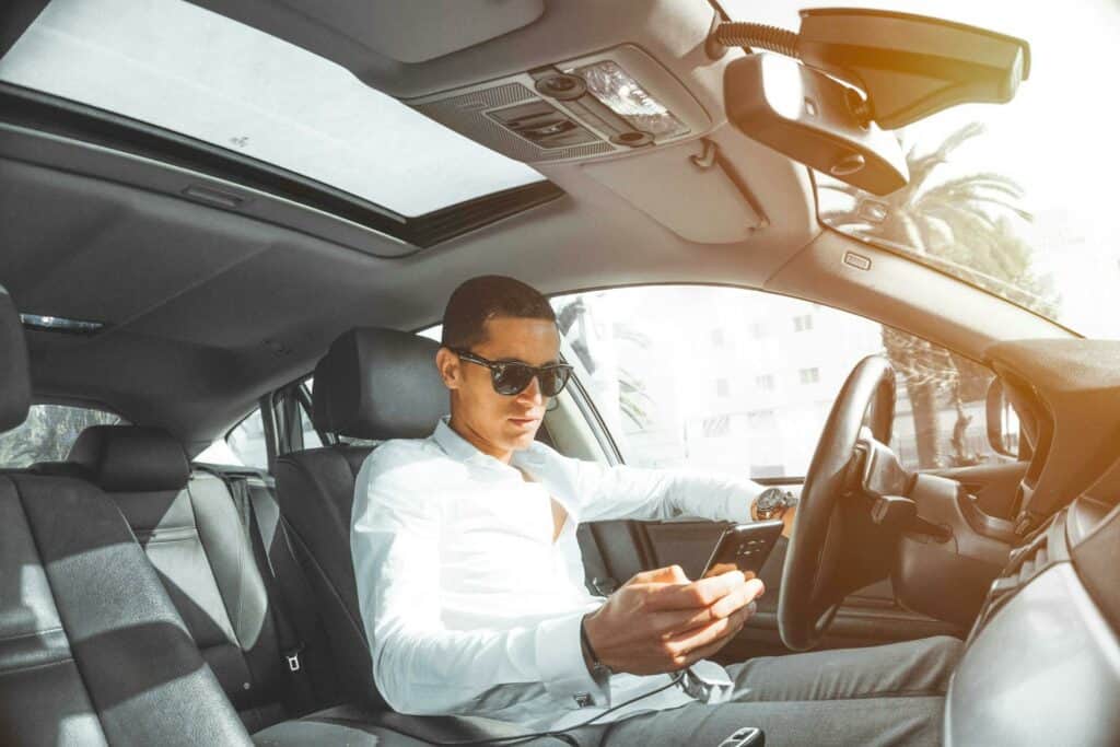 Un conductor distraído utilizando su teléfono mientras conduce su carro.