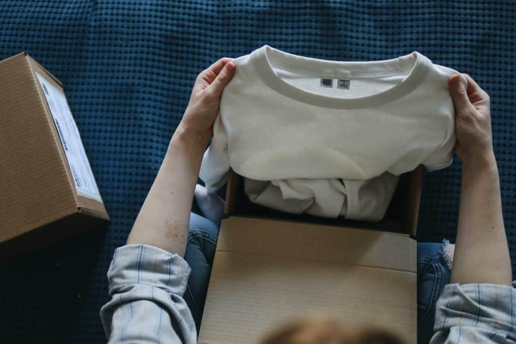 A person holding up a t-shirt from a package from Shein or Temu.