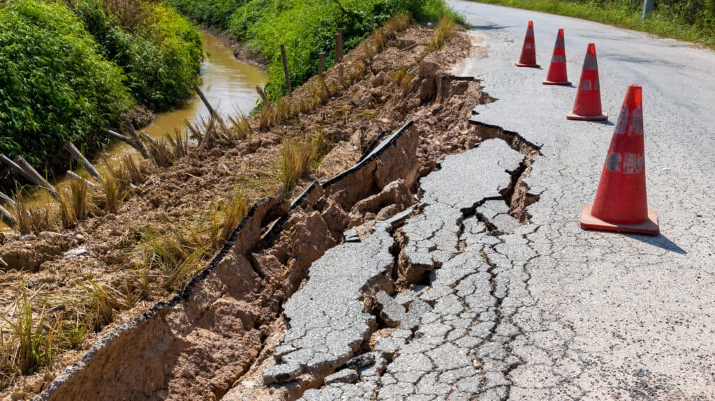 Cracked pavement on a road after a mudslide caused by rain.
