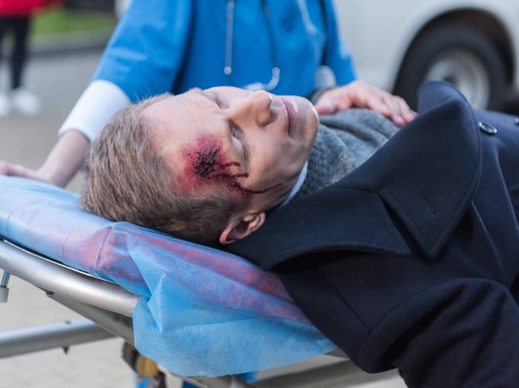 Doctor helps a man with facial injuries after an accident.
