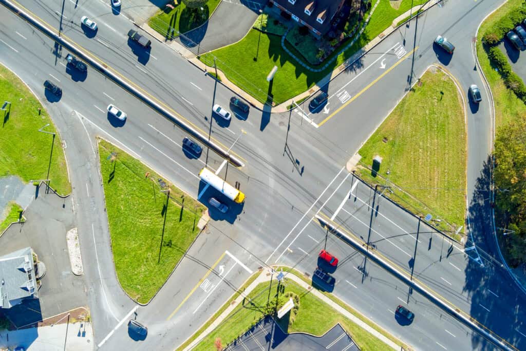 Vista aérea de una intersección señalizada por semáforos con automóviles cruzando.