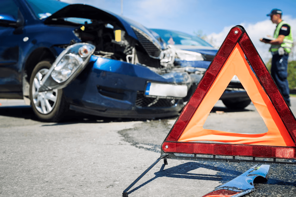 Foto de un auto azul dañado tras una colisión.