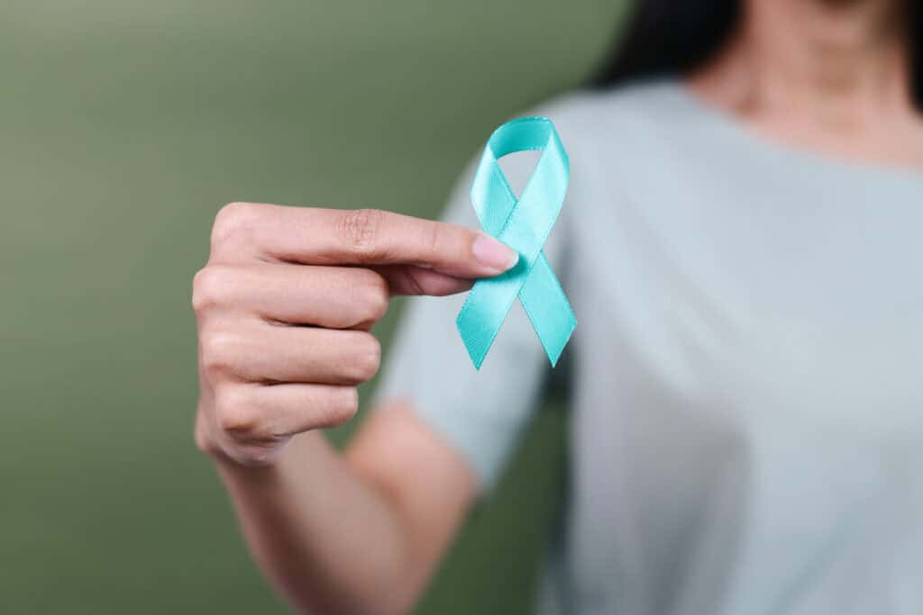 Image of a woman holding the sexual assault awareness ribbon.