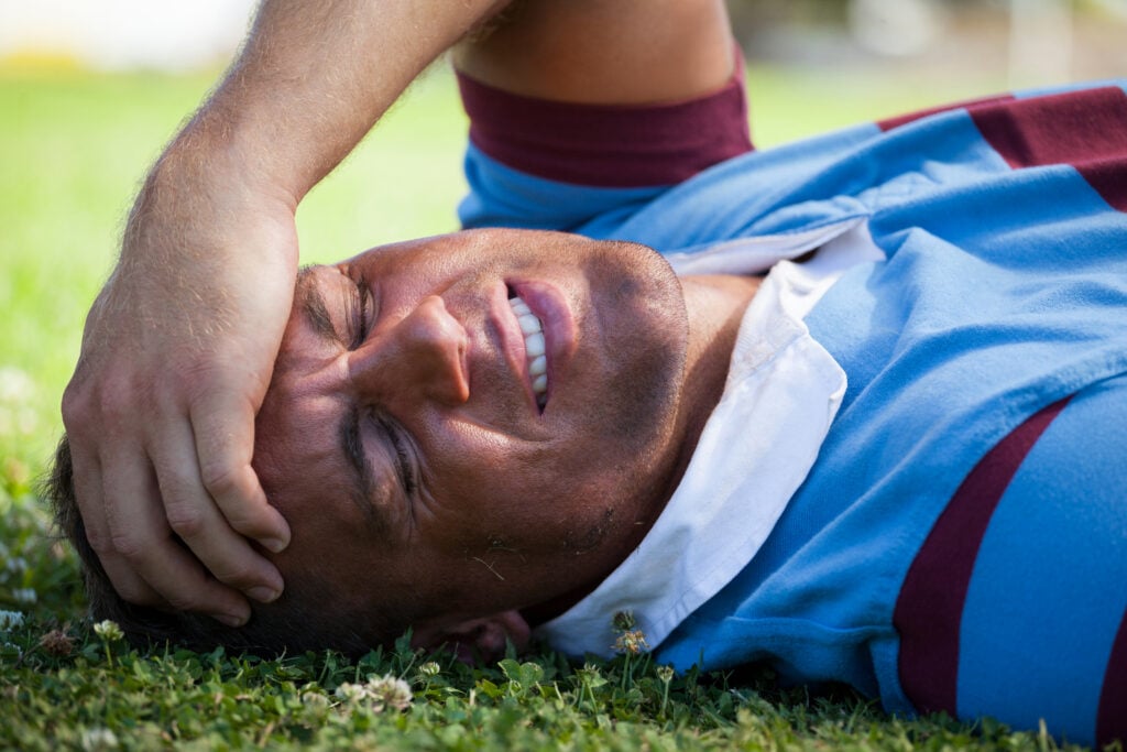 Victim of a personal injury accident lying on the ground after sustaining a concussion.