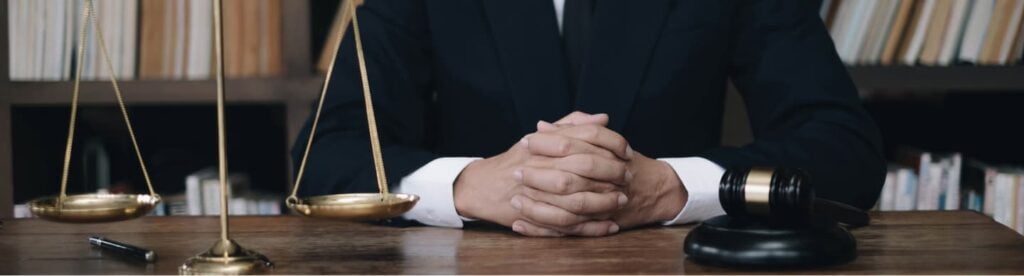 Riverside accident lawyer sitting at a table next to a scale and gavel.