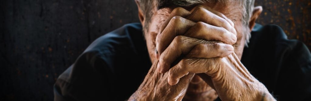 Elderly person cries in his room.