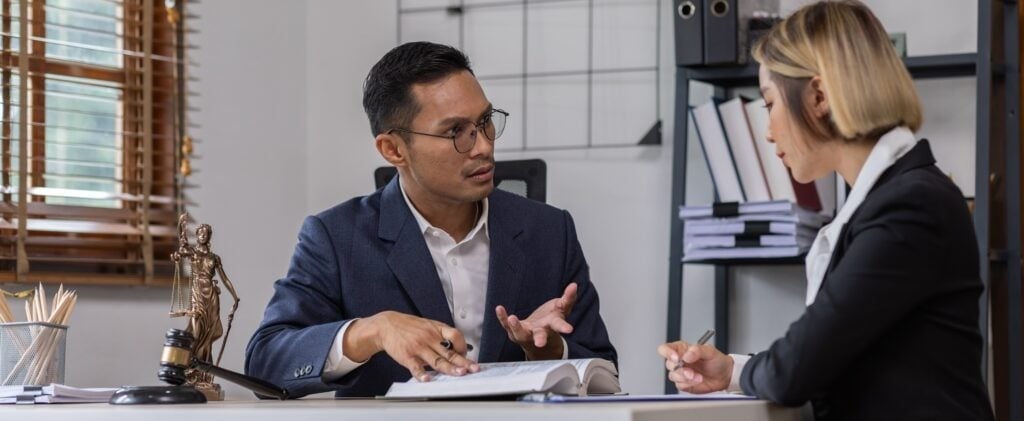 A personal injury lawyer talks to his assistant during a case consultation.