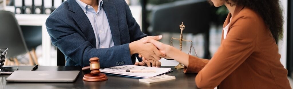 A bicycle accident lawyer shakes hands with his client.