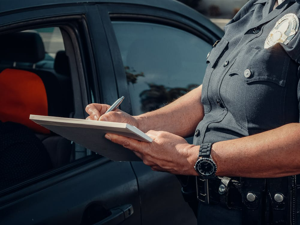 Police officer giving a driver a ticket for distracted driving accident.