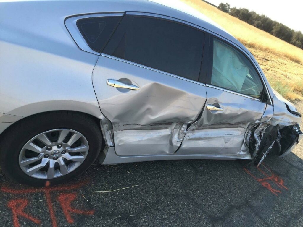 Vehículo dañado tras ser embestido por conductor distraído.