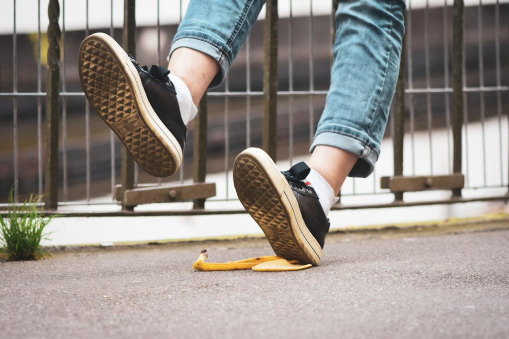 Feet slipping on a banana peel causing a trip-and-fall injury.