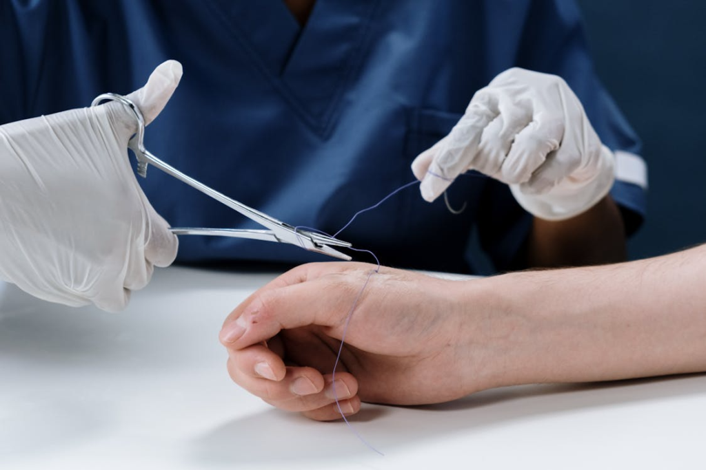 Doctor stitching up a victim who has an infection from a dog bite.