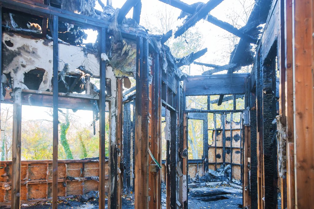 Casa quemada con graves daños materiales tras incendios forestales en California.