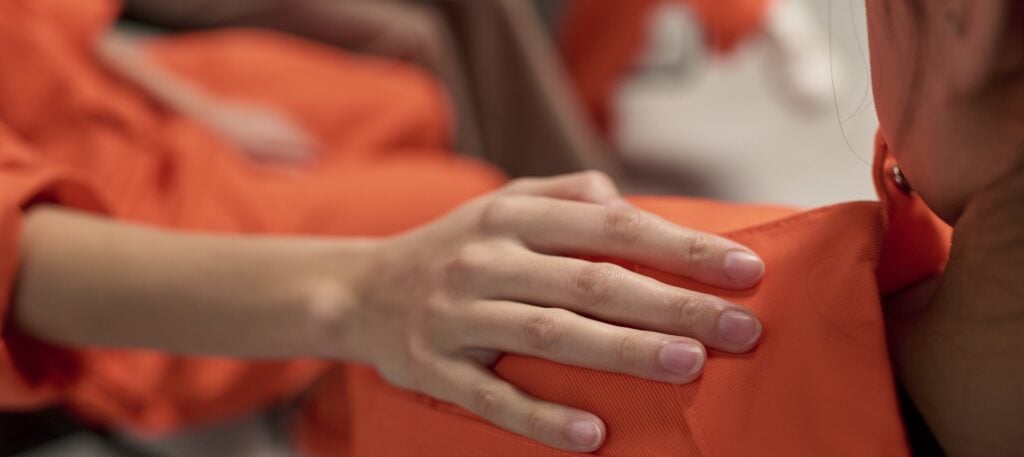 A female inmate at the CRDF places her hand on a fellow inmate’s shoulder.