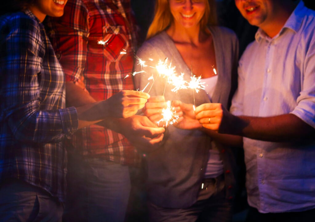 Reunión familiar del 4 de julio con fuegos artificiales en un jardín