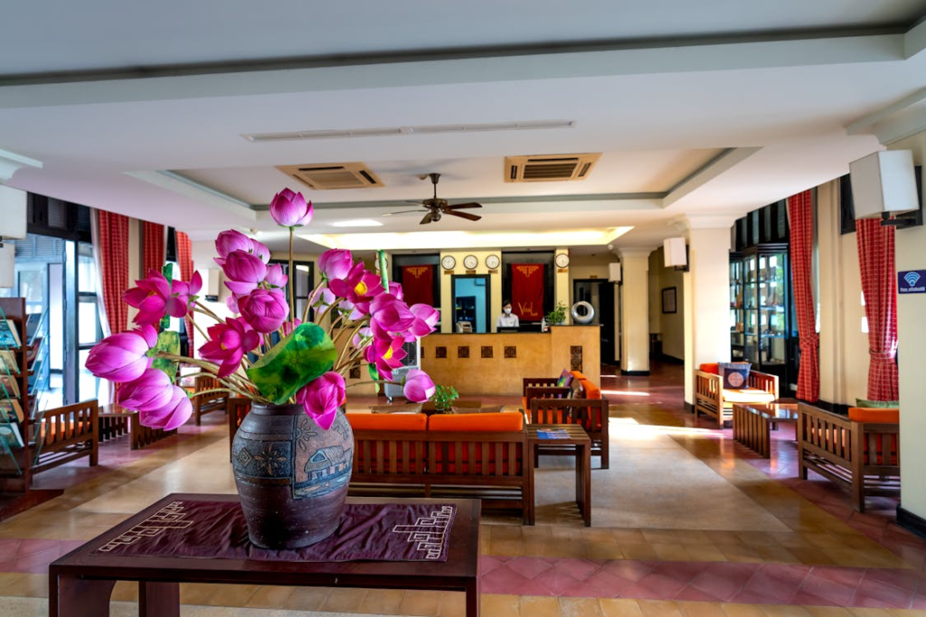 Hotel lobby with seating area, decorative flowers, and security features