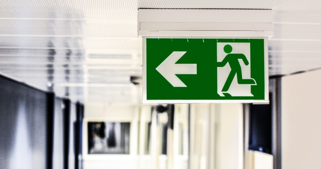 Emergency exit sign inside a building indicating an evacuation route during a wildfire emergency.