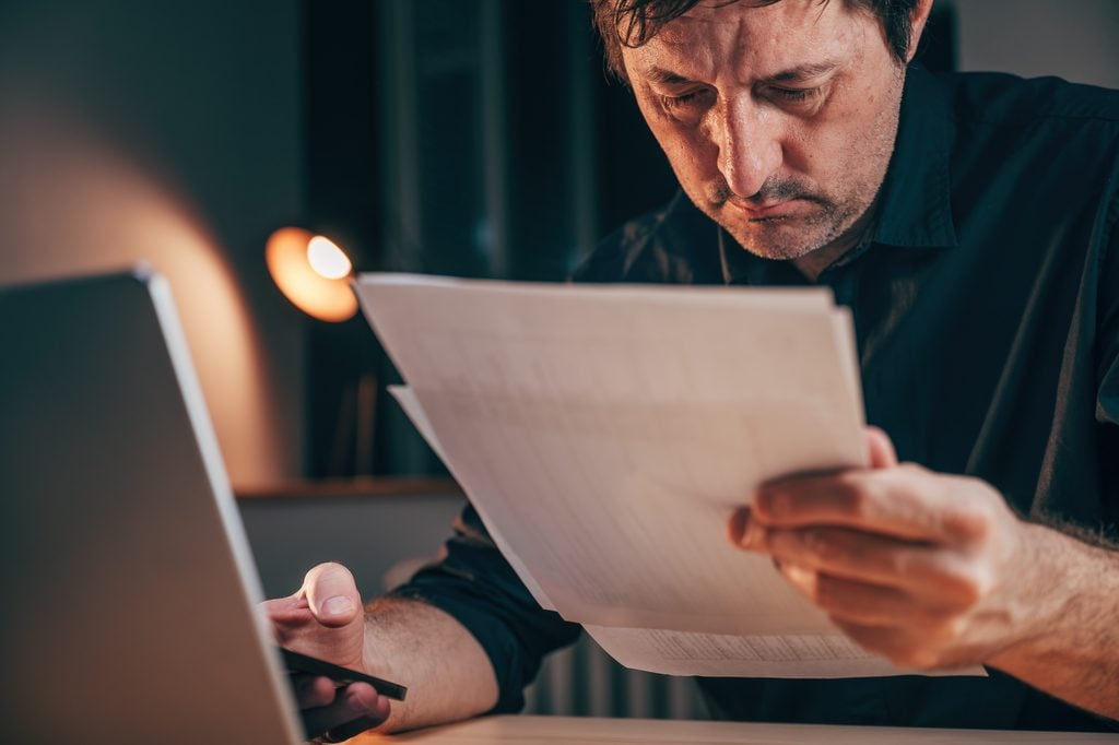 Man reviewing compensation documents from SCE related to the Eaton Fire